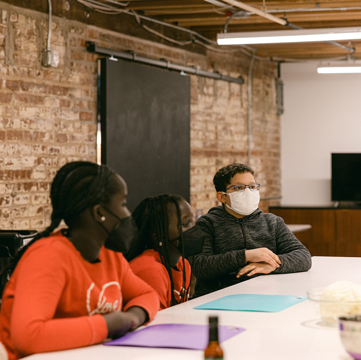 Three children sit at a table.